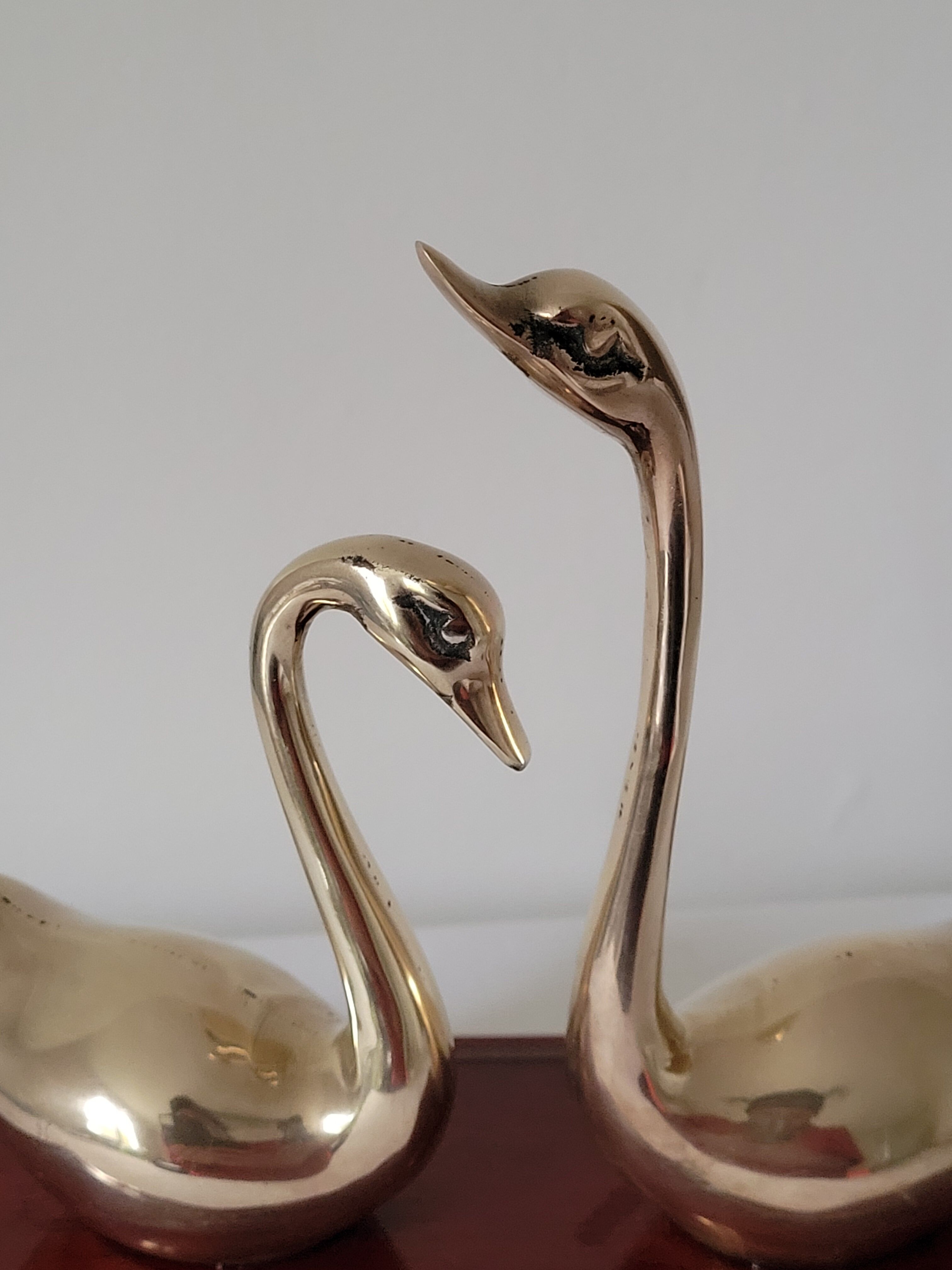 Duo of brass swans on base