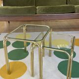 Pair of small nesting coffee tables in gold tubular metal & transparent glass tops
