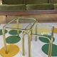 Pair of small nesting coffee tables in gold tubular metal & transparent glass tops