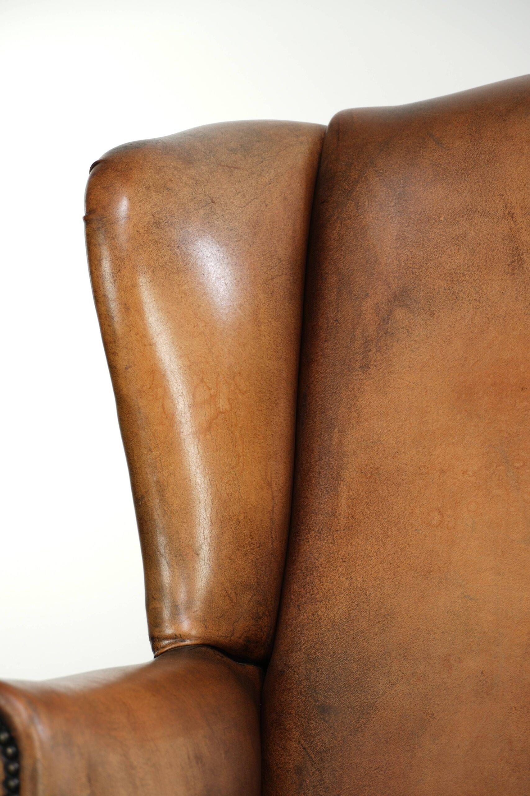 Sheepskin wingback armchair with patina finished with decorative nails