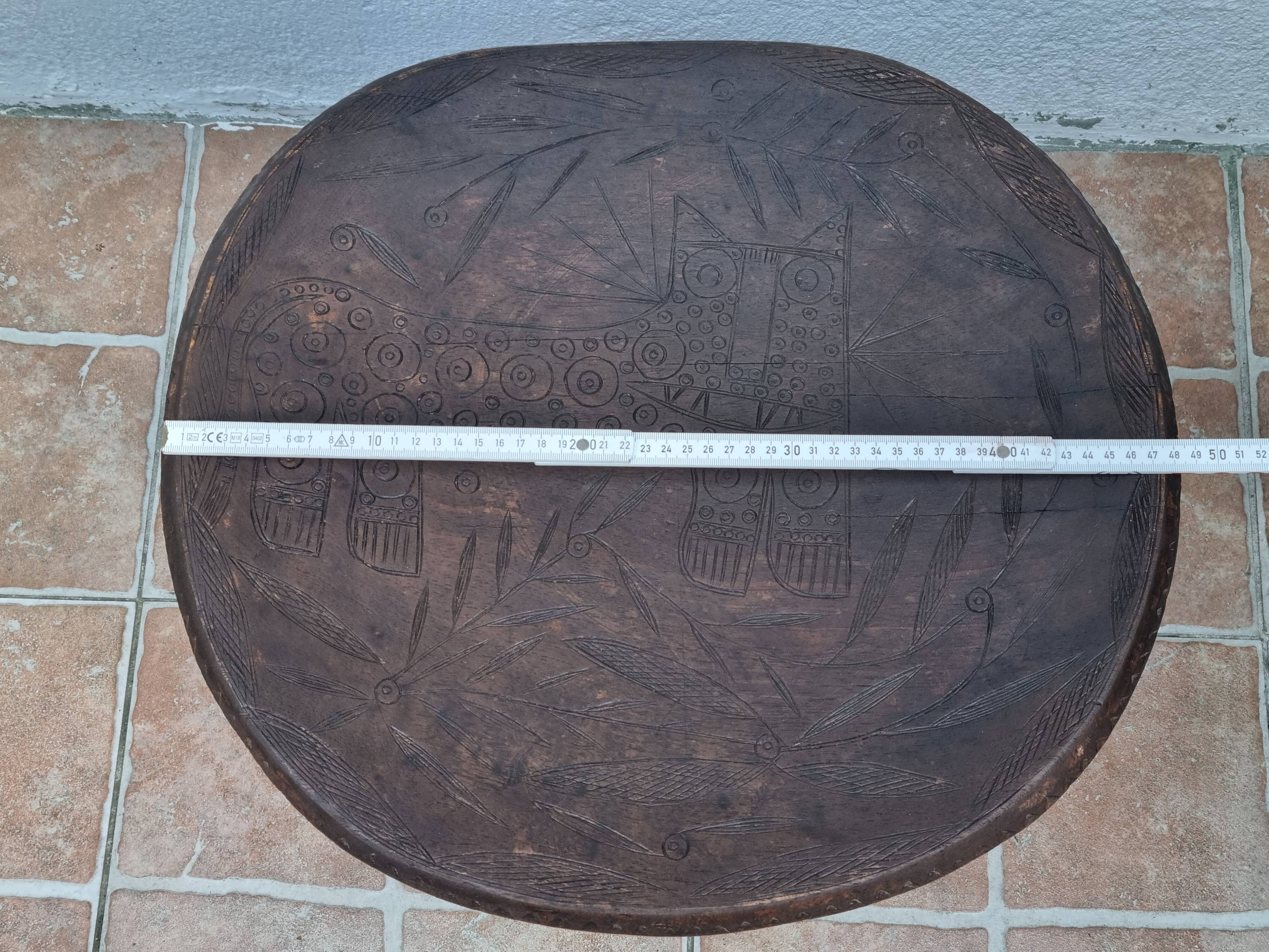 African monoxyle side table in carved wood with a curved top, 48x36 cm.