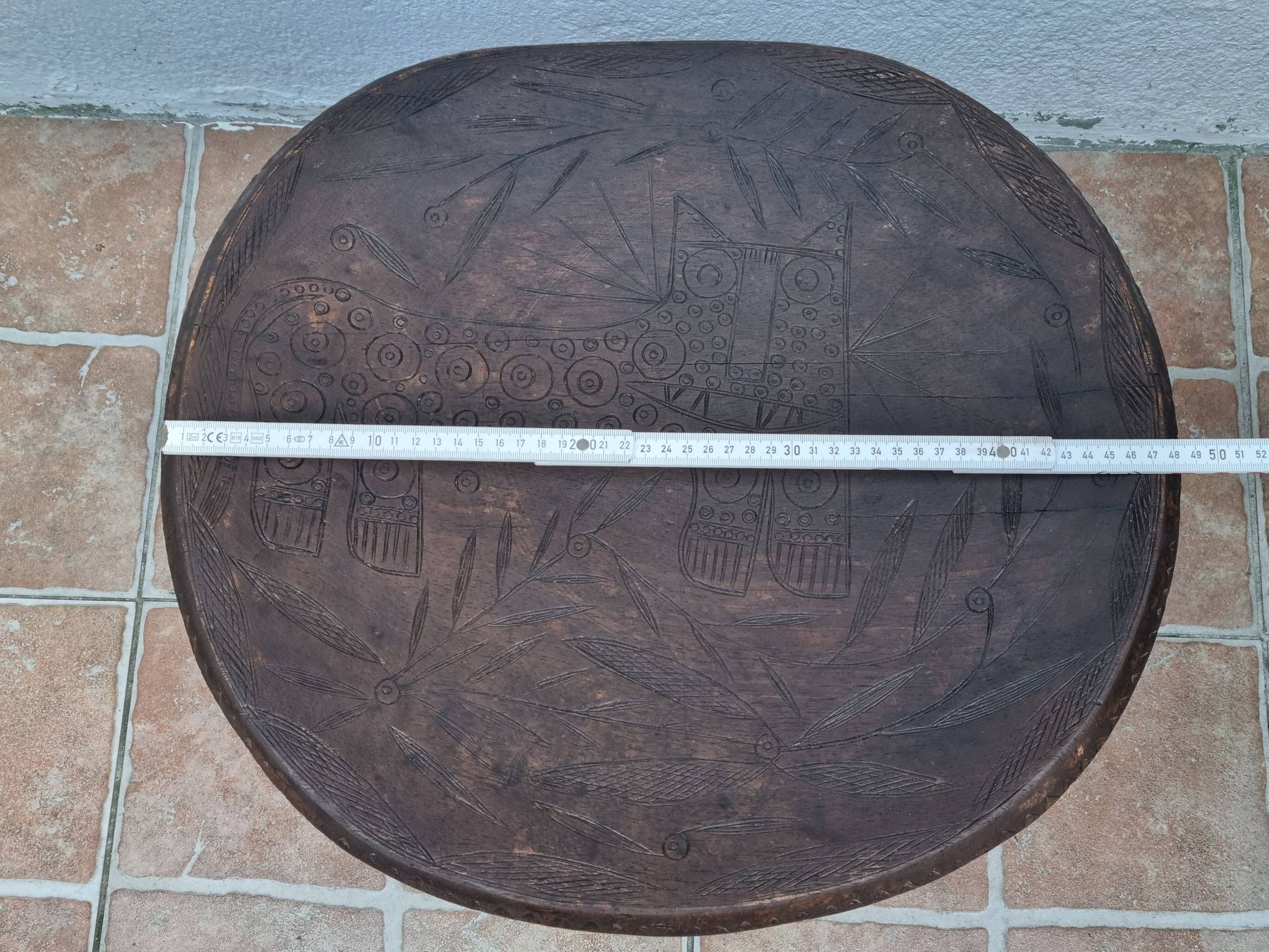 African monoxyle side table in carved wood with a curved top, 48x36 cm.