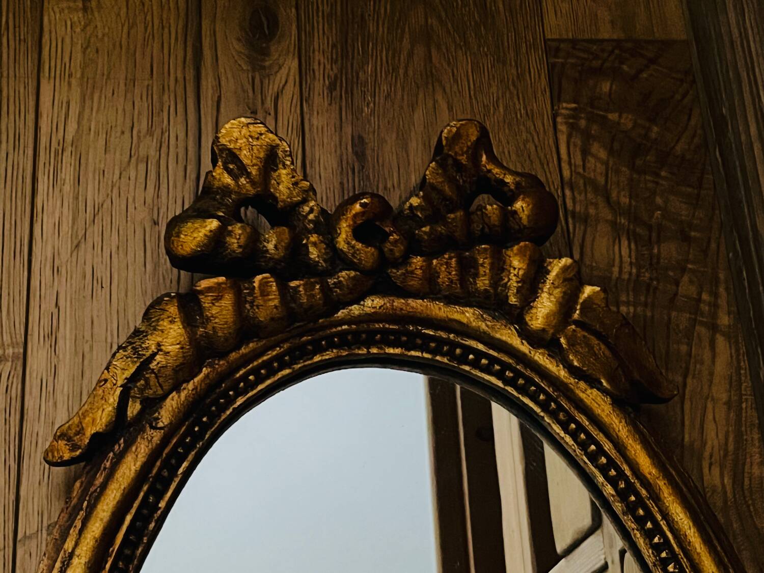 Old oval gilded stucco mirror