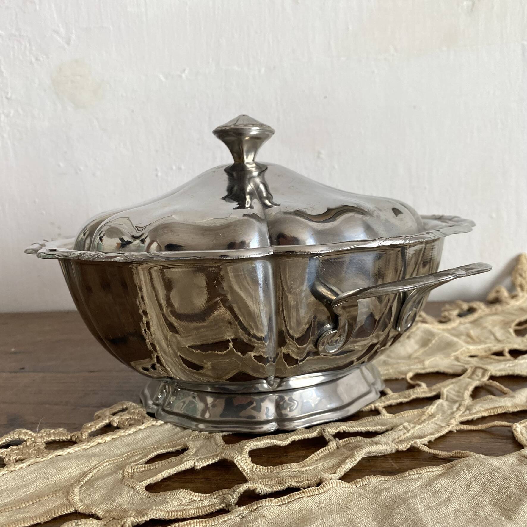 Vintage round stainless steel soup tureen with scalloped edges.