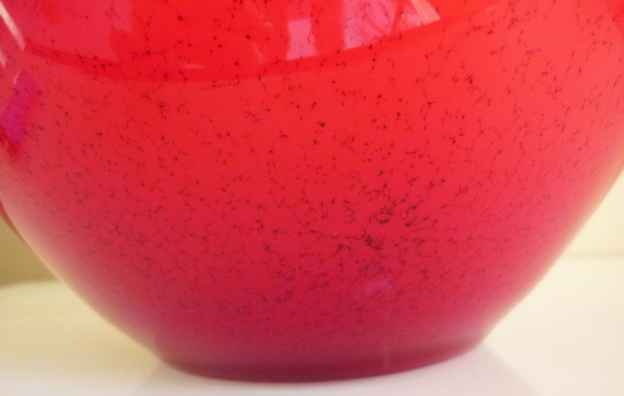 Pot-bellied, art deco vase in speckled ruby red multi-layered glass, white interior