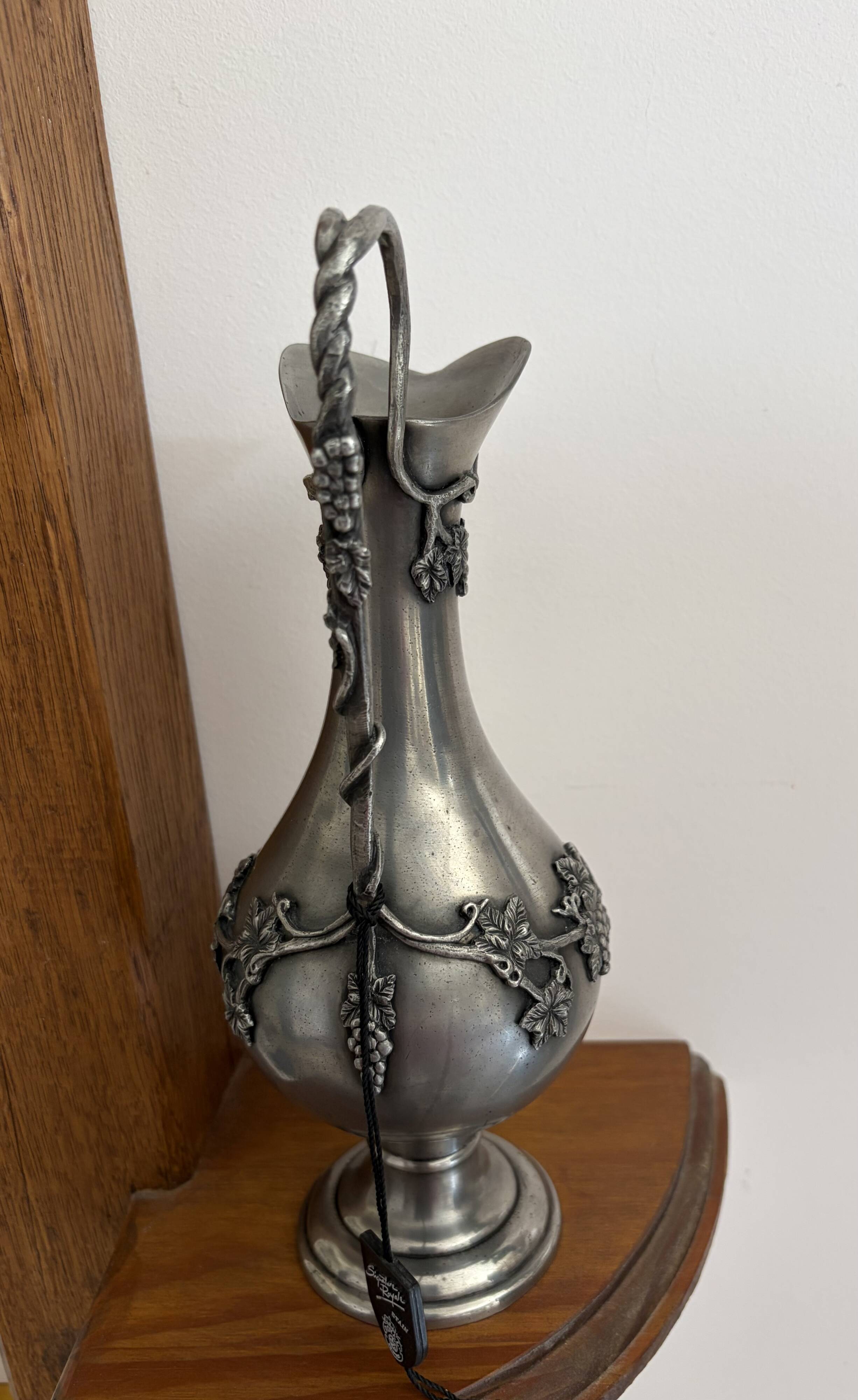 Ewer in pewter surrounded by vine branches with g