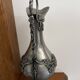 Ewer in pewter surrounded by vine branches with g
