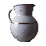 Old enamelled metal jug with gold trim.