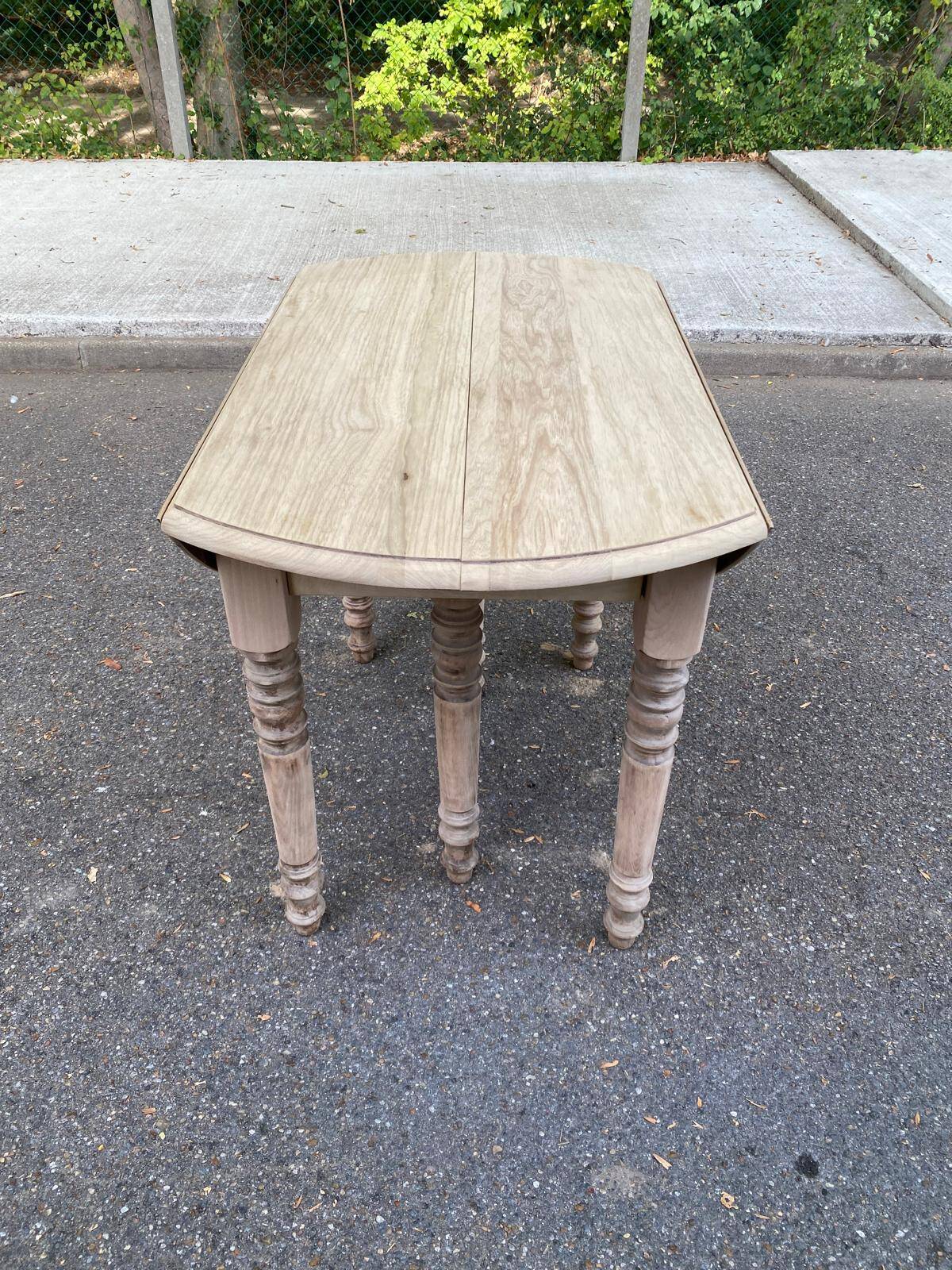 Round extendable dining table with flaps, stripped in raw oak, with 3 extensions.