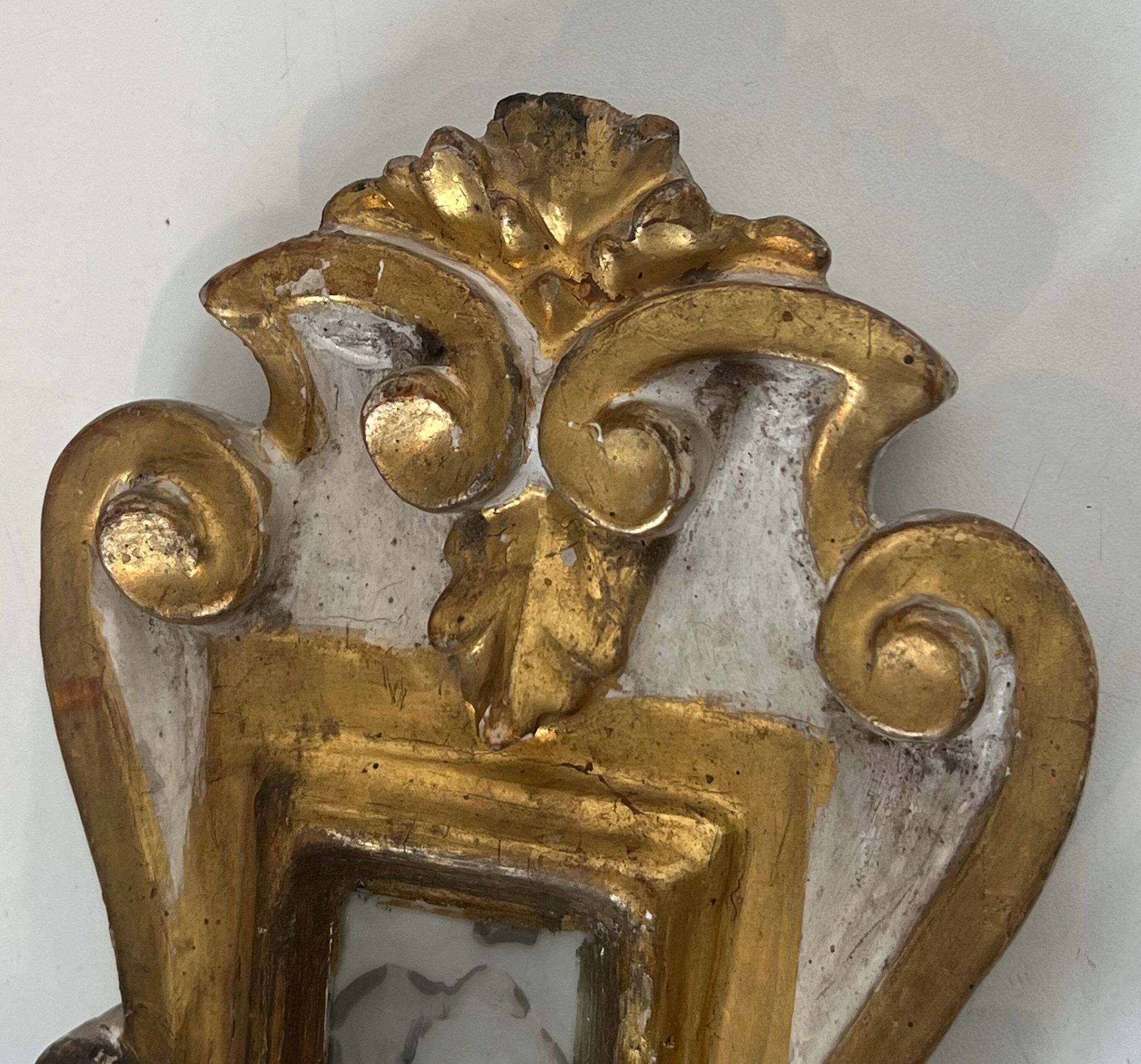 Pair of wall sconces in carved wood and silvered and gilded patinated metal with a central mirror.