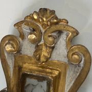 Pair of wall sconces in carved wood and silvered and gilded patinated metal with a central mirror.