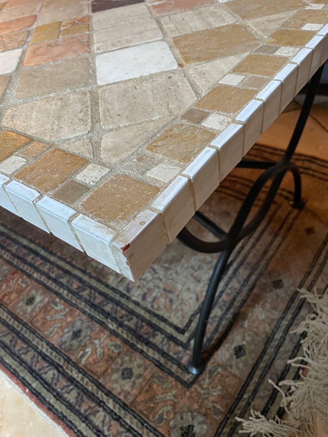 Beige ceramic coffee table with black metal legs.