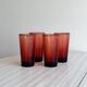 4 verres à eau rouges translucides.