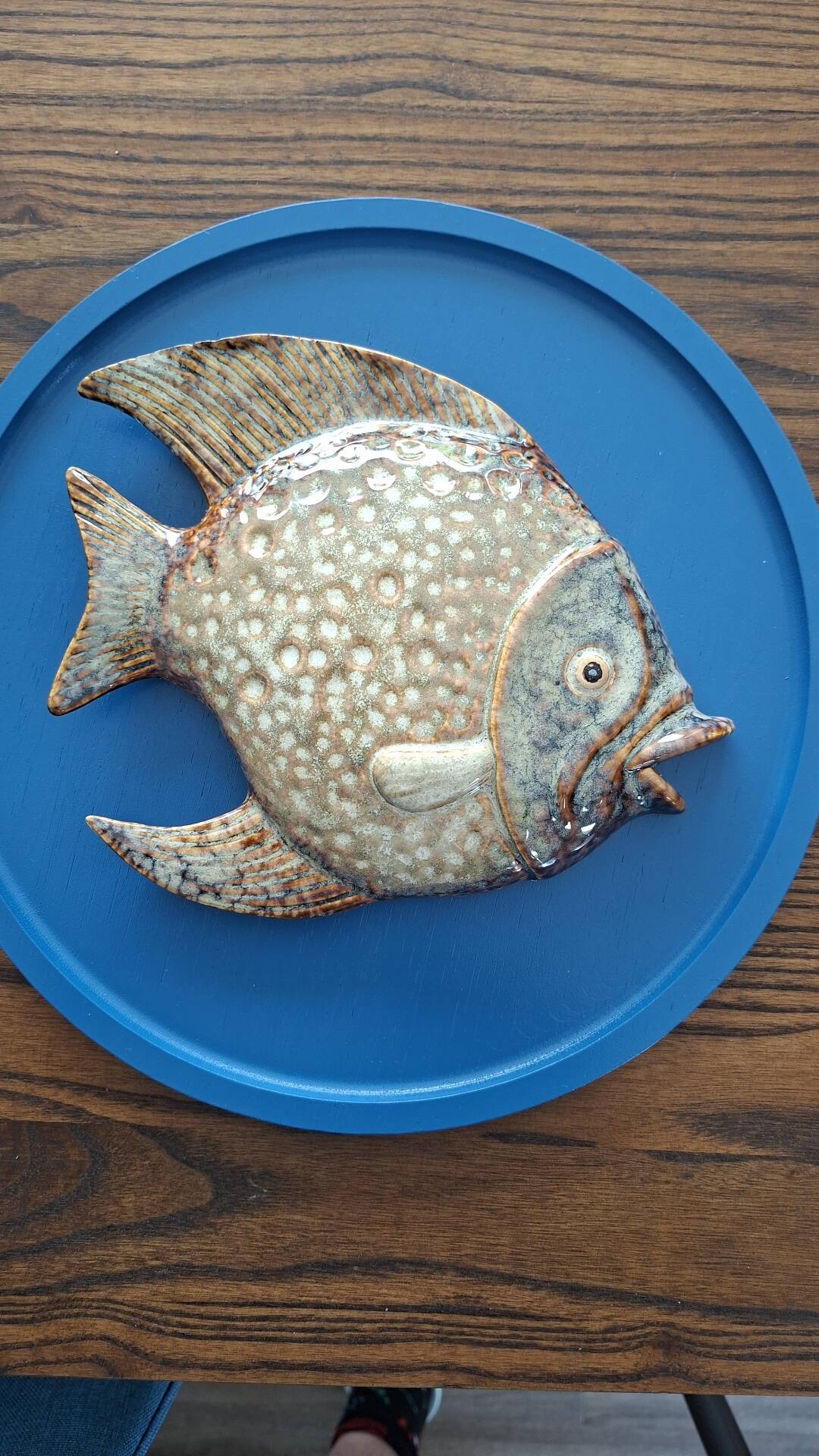 Vallauris ceramic wall sculpture of a relief fish on a blue plaque.