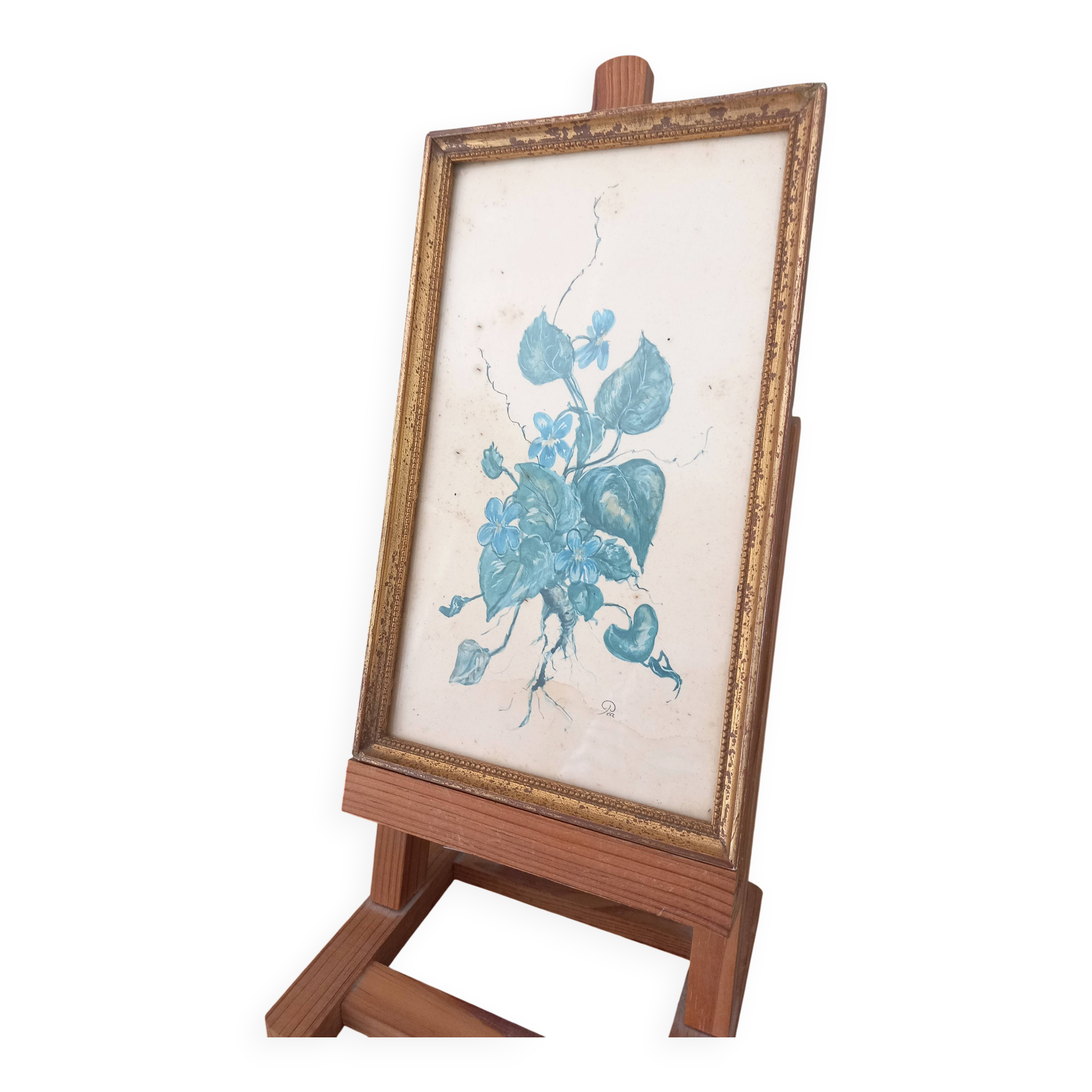 Decorative table with vintage blue flowers in a golden frame.