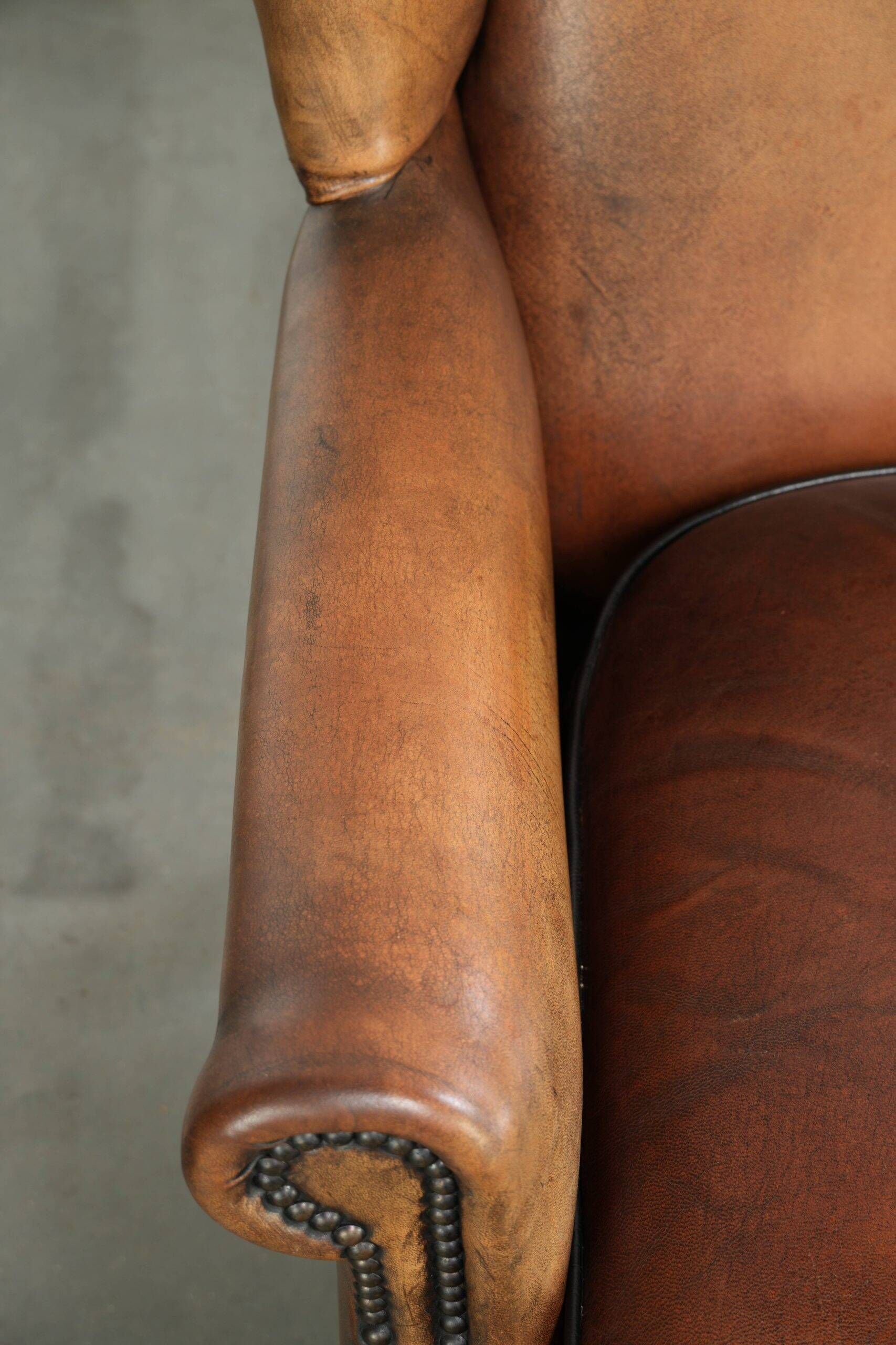 Sheepskin wingback armchair with patina finished with decorative nails