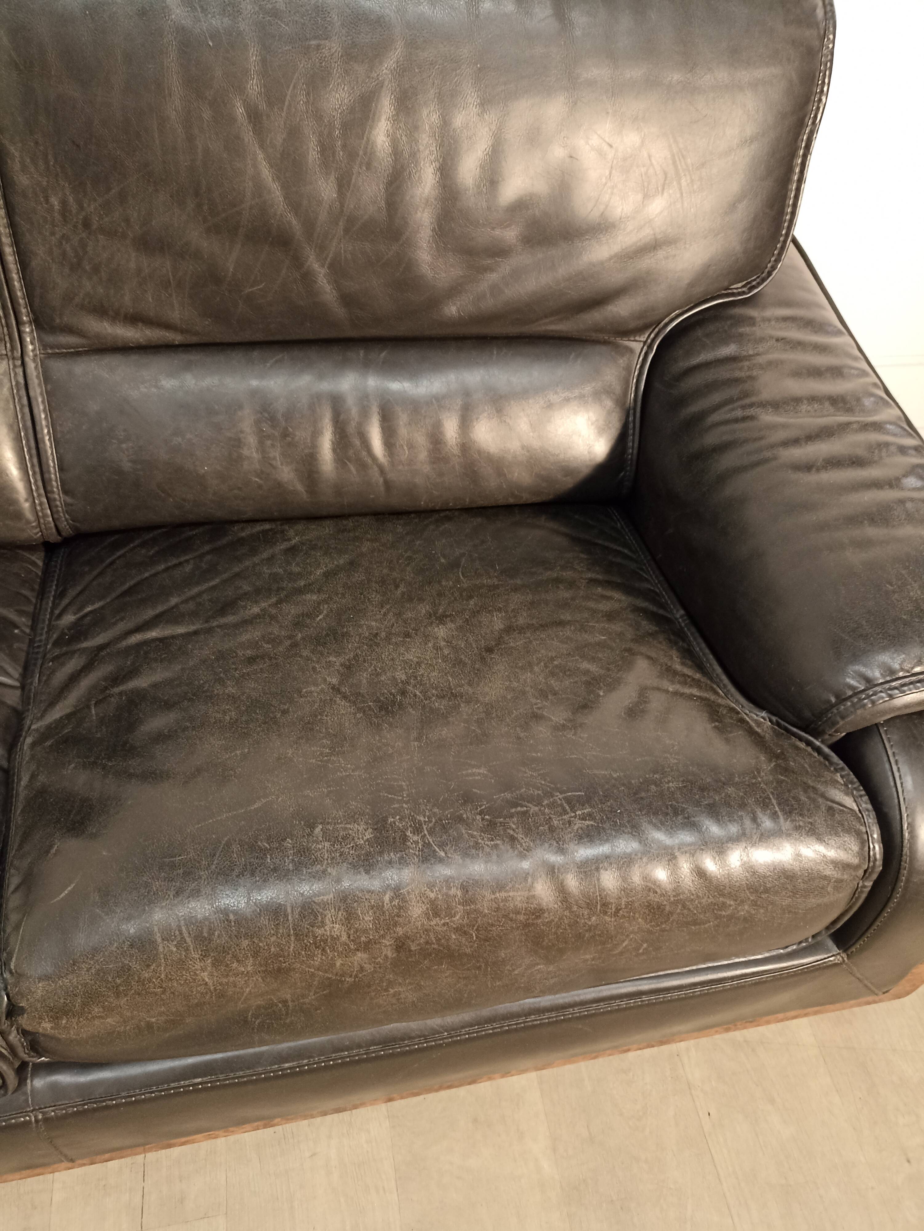 Black leather sofa and wooden armrests
