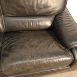 Black leather sofa and wooden armrests