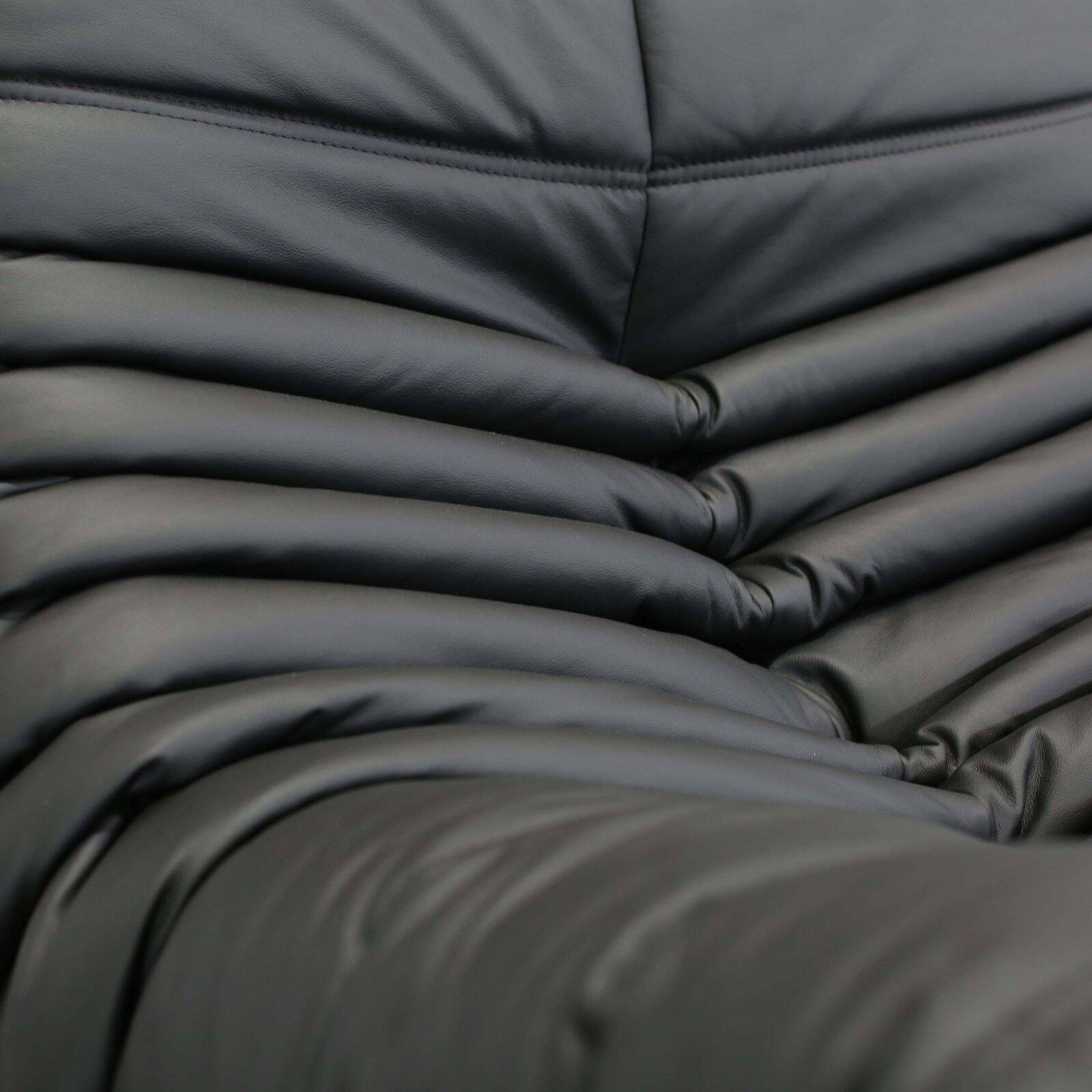 Togo armchair and footrest in black leather by Ligne Roset, designed by Michel Ducaroy.