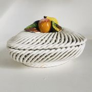 Covered basket in white woven ceramic and fruit slip.