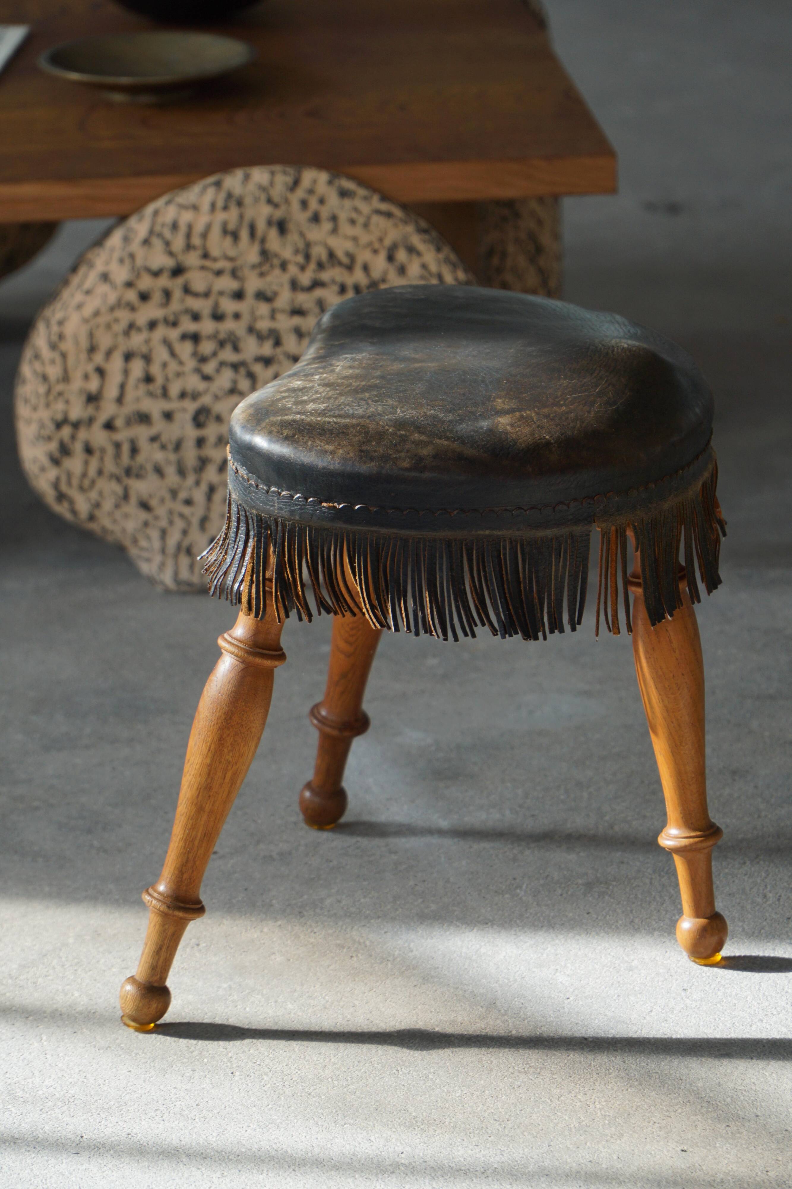 Danish oak tripod stool from the early 20th century with leather fringe, 1930s.