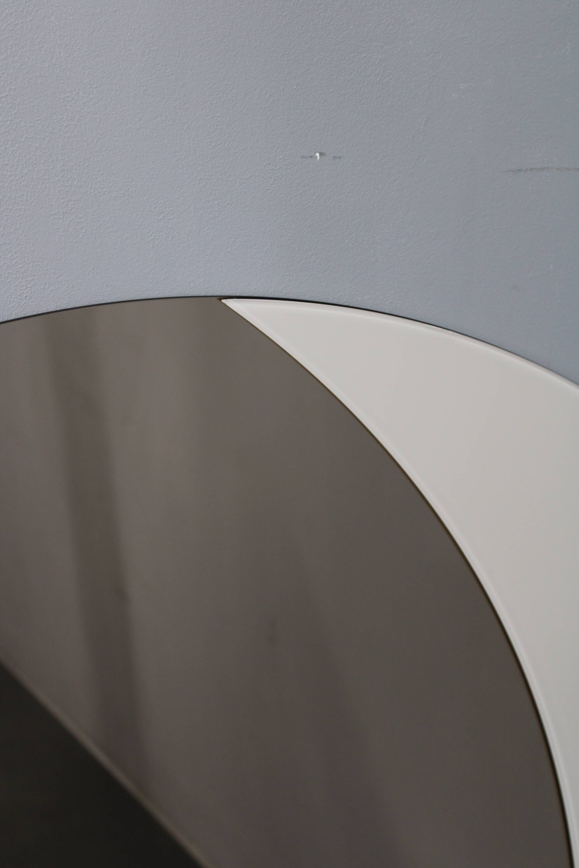 Large 1980s Italian smoke-tinted round mirror with white geometric segment