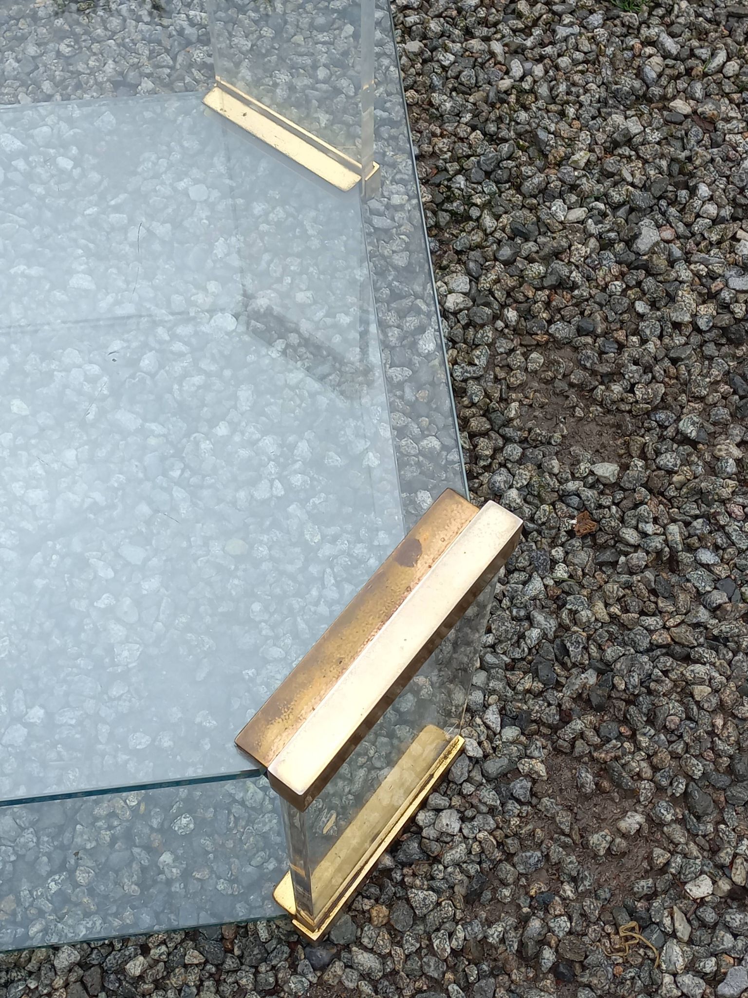 1970s designer coffee table in glass, plexiglass, and gold metal.