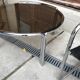 Mid-century round coffee table in chrome and smoked glass with 2 black leather chairs.