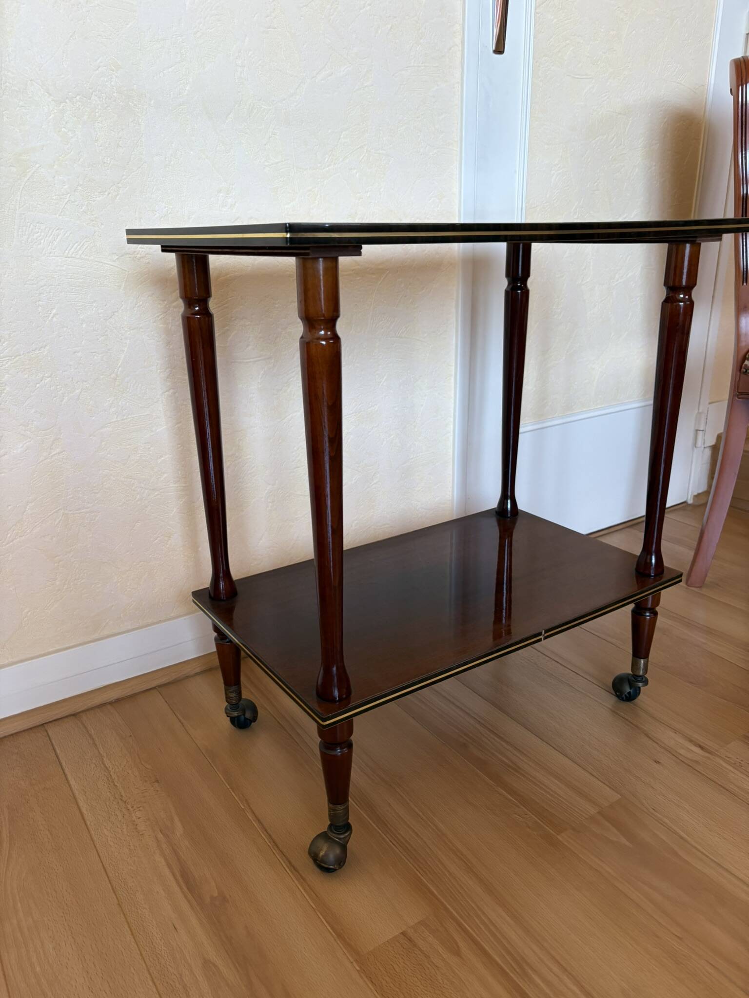 Table d’appoint vintage en bois verni, à roulettes et filets dorés