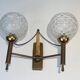 Pair of brass wall lights with glass globes. Around 1970.