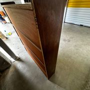 Vintage 1960s wooden library with sliding doors.