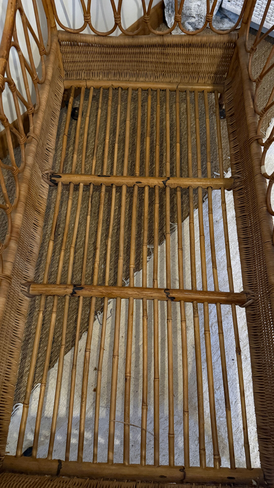 Vintage rattan baby cot on wheels.
