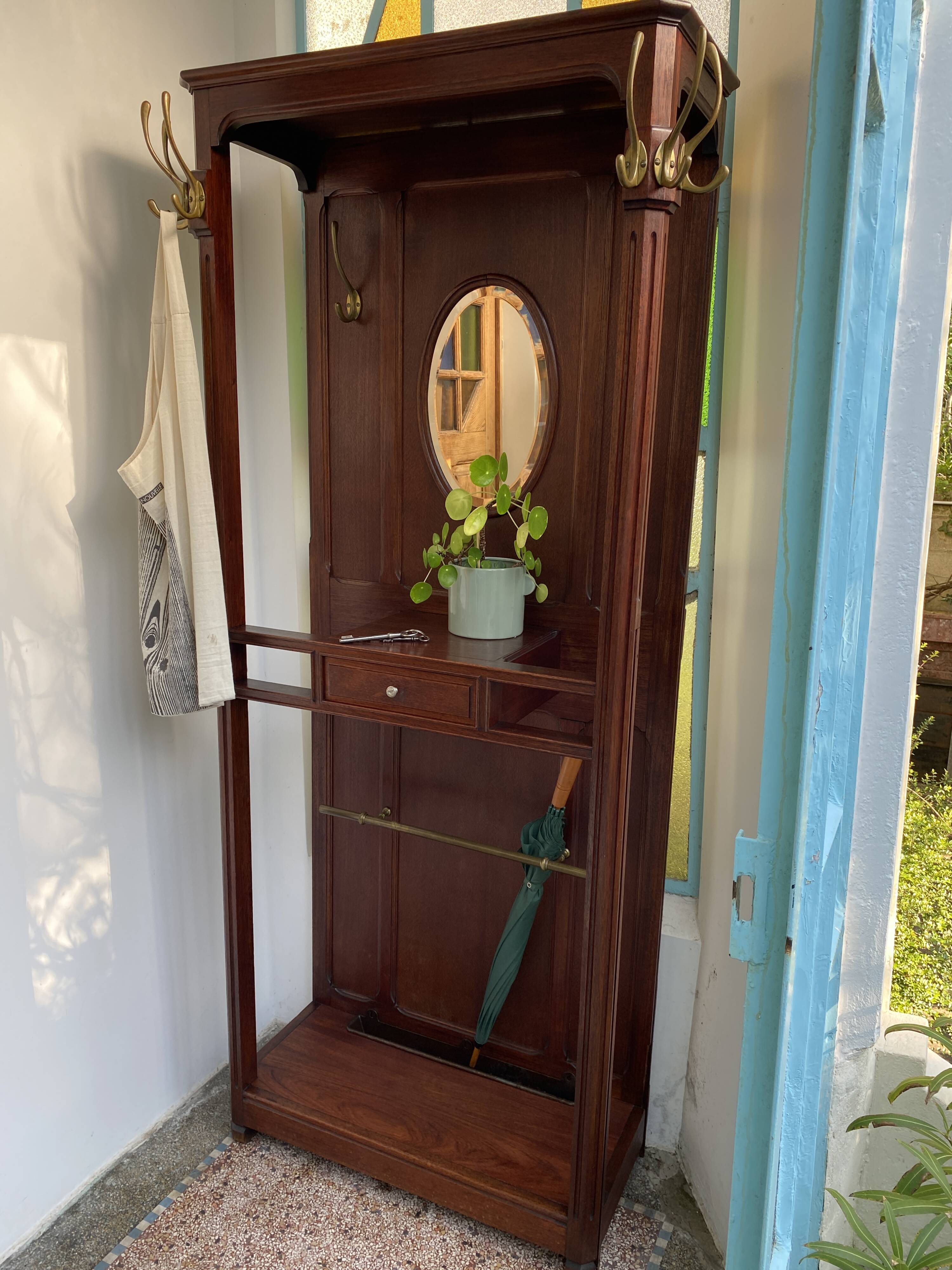 Antique wooden coat rack with mirror and shelf.