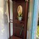 Antique wooden coat rack with mirror and shelf.