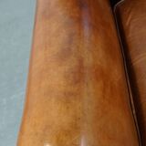 Fauteuil ancien en cuir de mouton couleur cognac