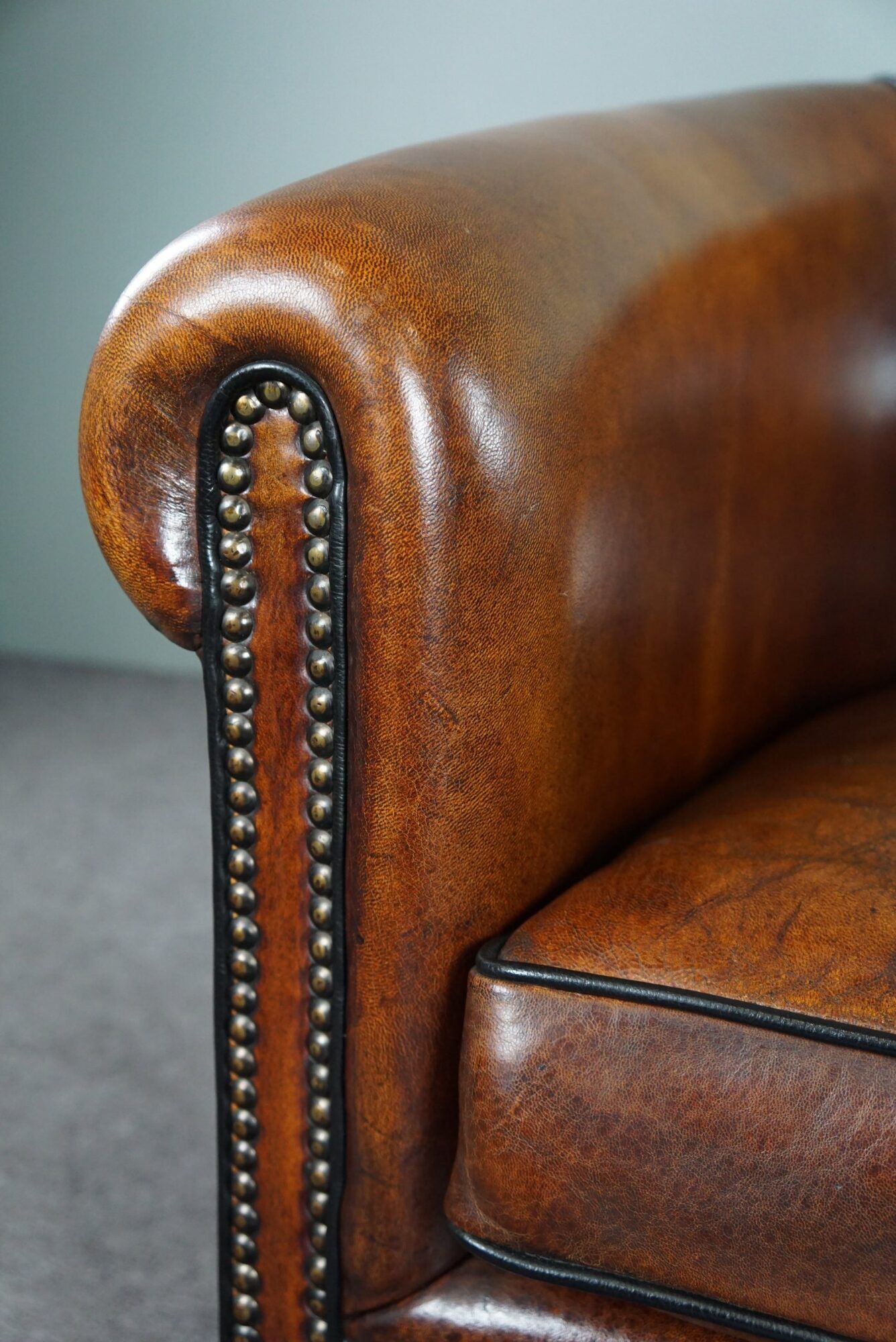Club armchair in sheepskin with black piping