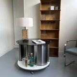 Vintage metal and smoked glass coffee table on casters bar