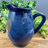 Blue ceramic pitcher with vintage artisan inscription decoration.