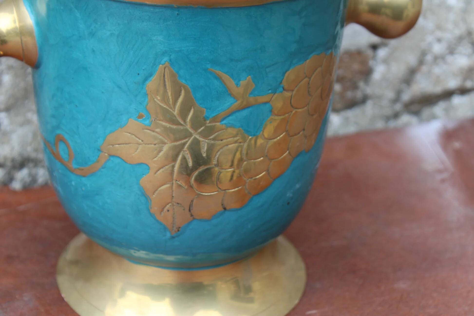 Vintage turquoise brass champagne bucket with grape decoration.