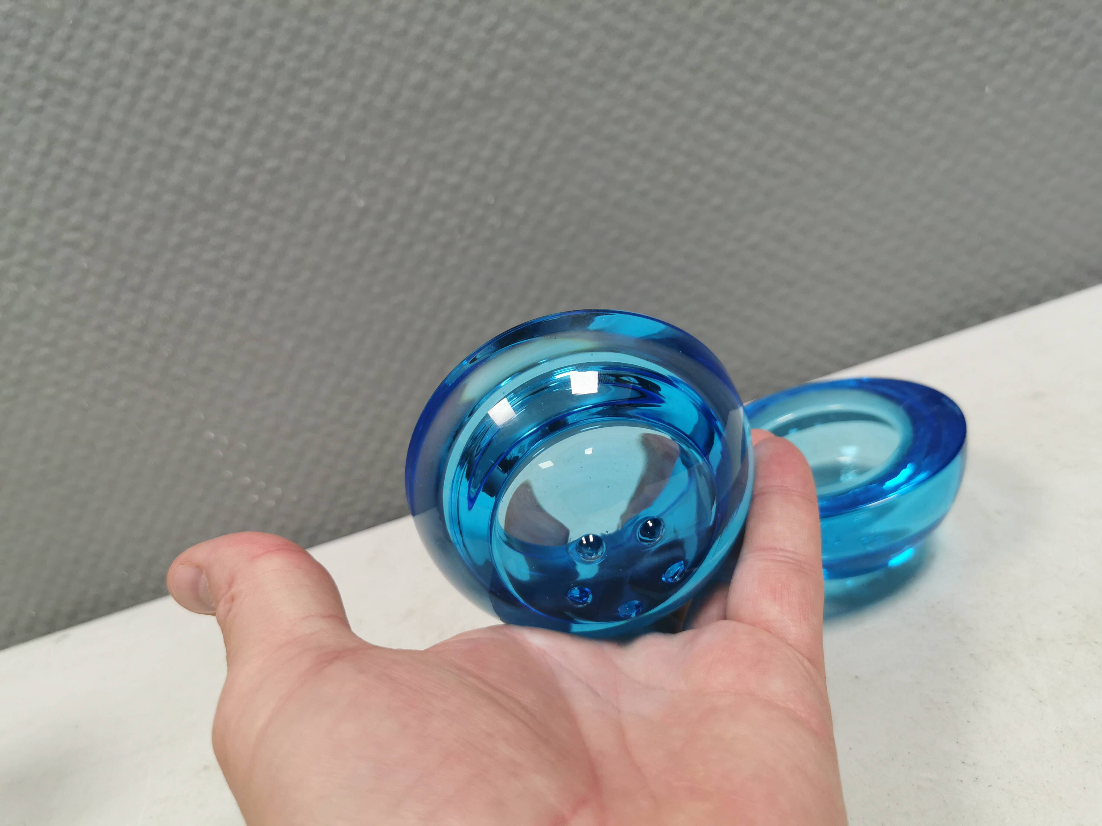A set of iitalla candle holders in blue transparent glass.