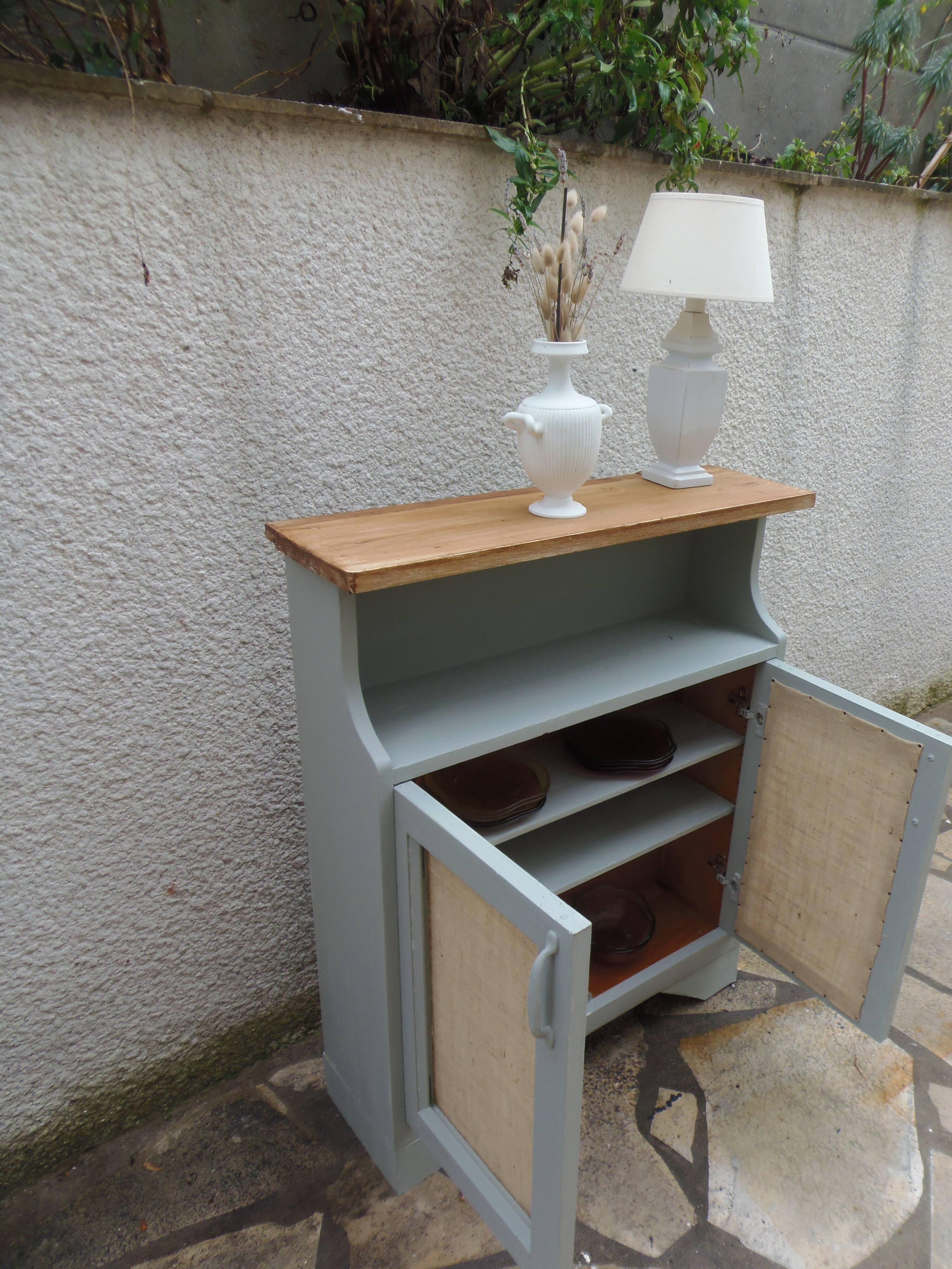 Small vintage green-grey piece of furniture, with 2 doors covered in burlap.