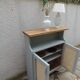 Small vintage green-grey piece of furniture, with 2 doors covered in burlap.