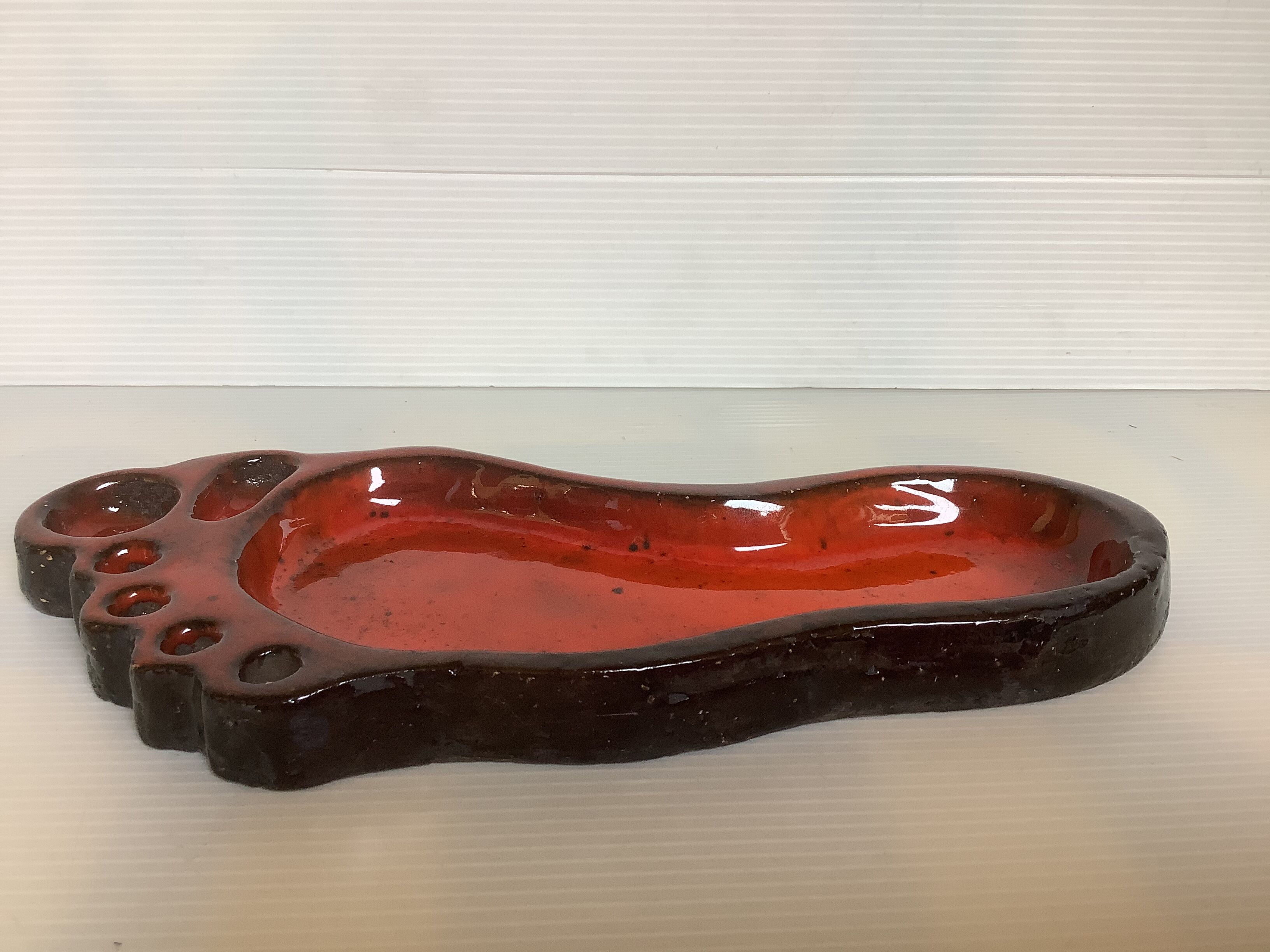 Red ceramic footprint catchall.