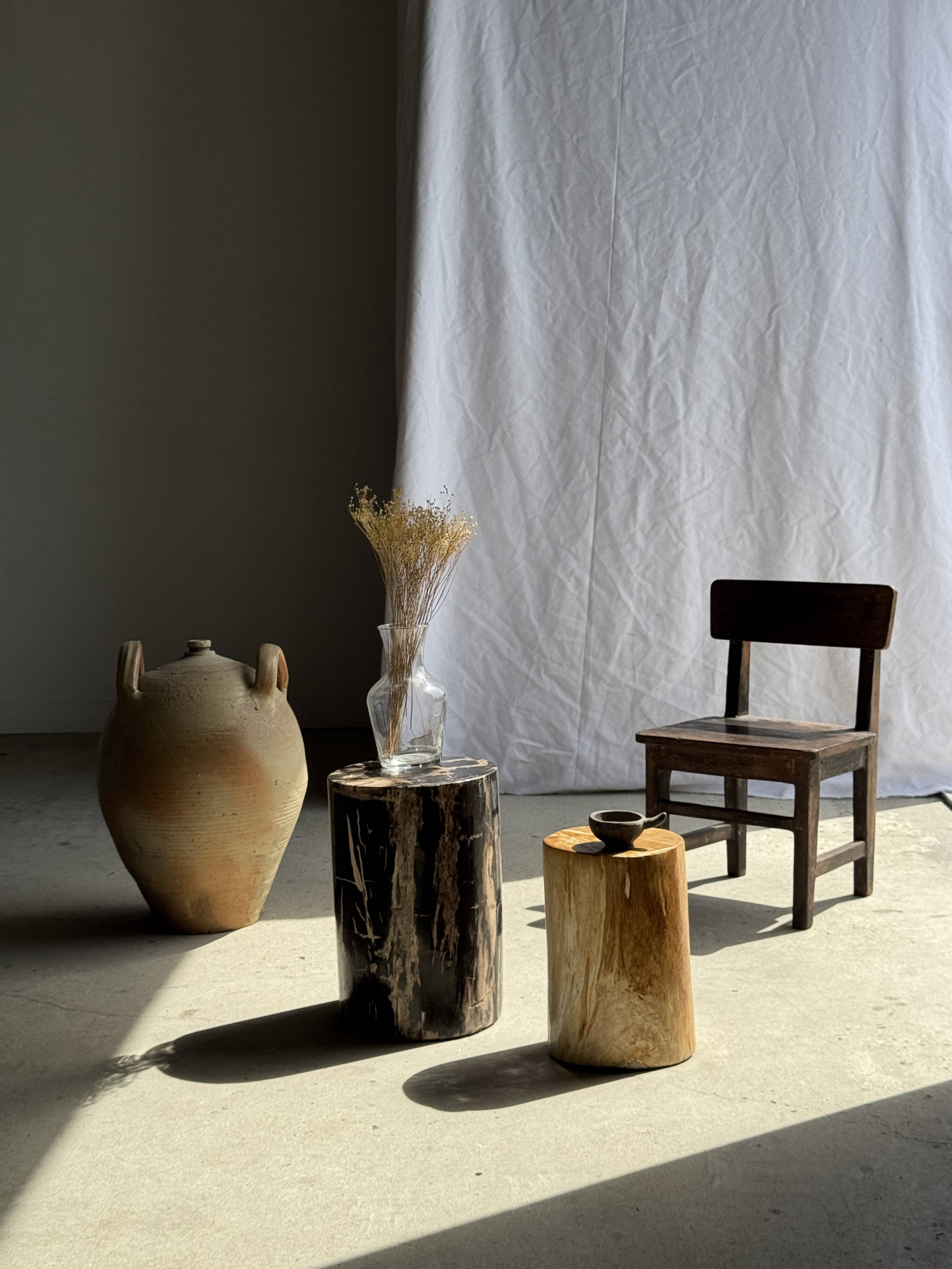 Black petrified wood side table with beige stripes and a semicircular shape.