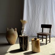 Black petrified wood side table with beige stripes and a semicircular shape.