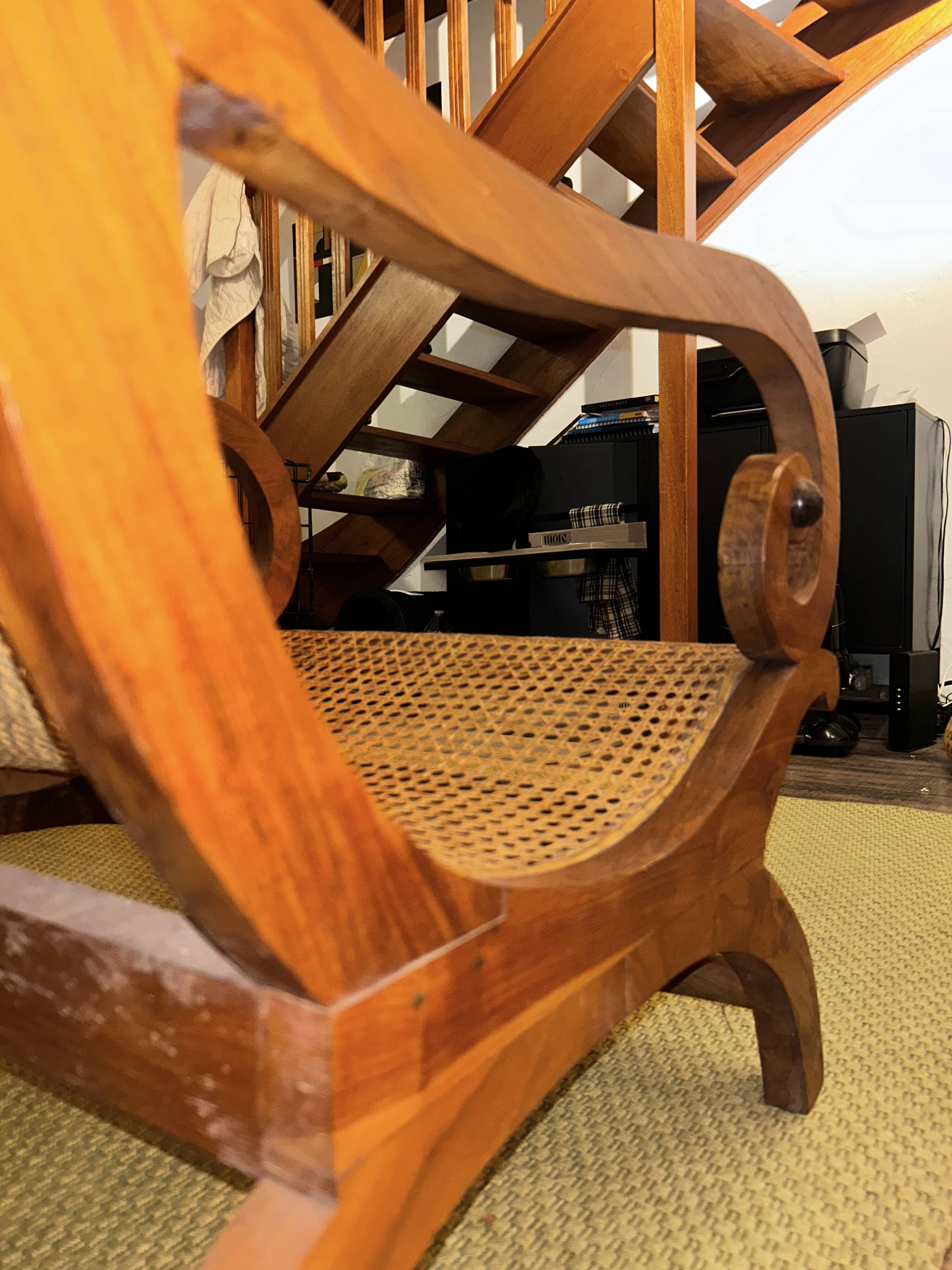 Colonial planter's armchair in solid teak, scroll armrests, caned seat.