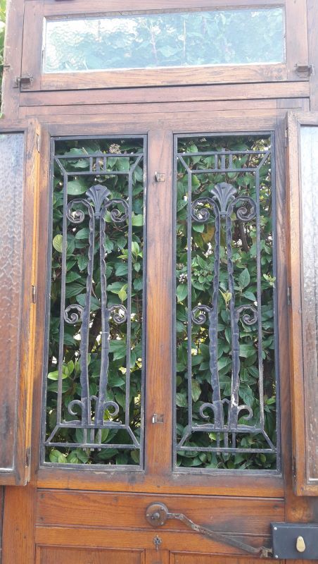 Oak entrance door and its frame and transom, wrought iron gates