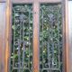 Oak entrance door and its frame and transom, wrought iron gates