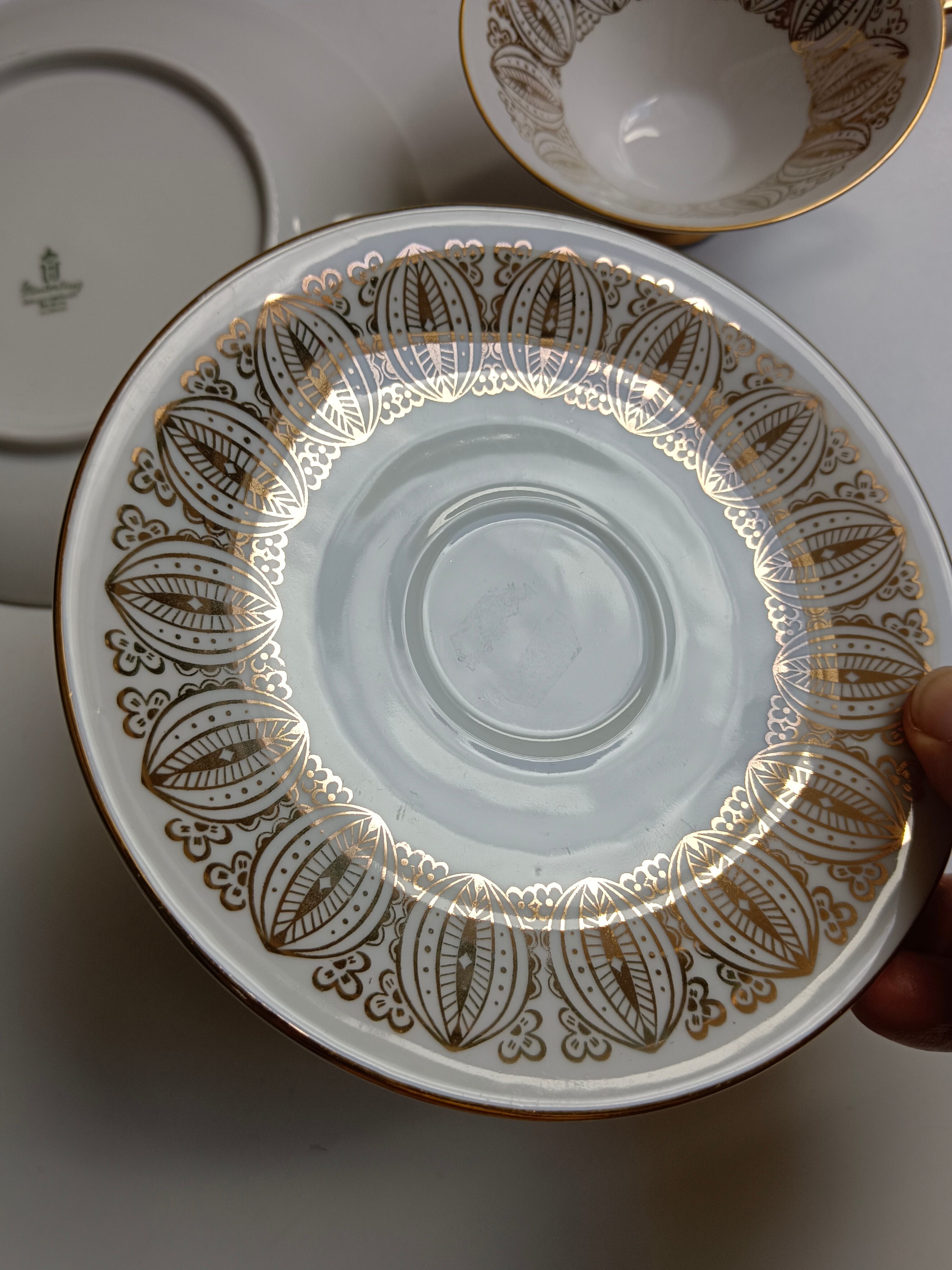 Solitaire tea cup, saucer, and dessert plate in white and gold.