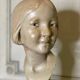 Plaster bust, young girl, monogram and date.